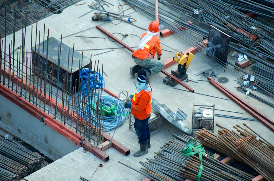 Site workers in hard hats taking measurements