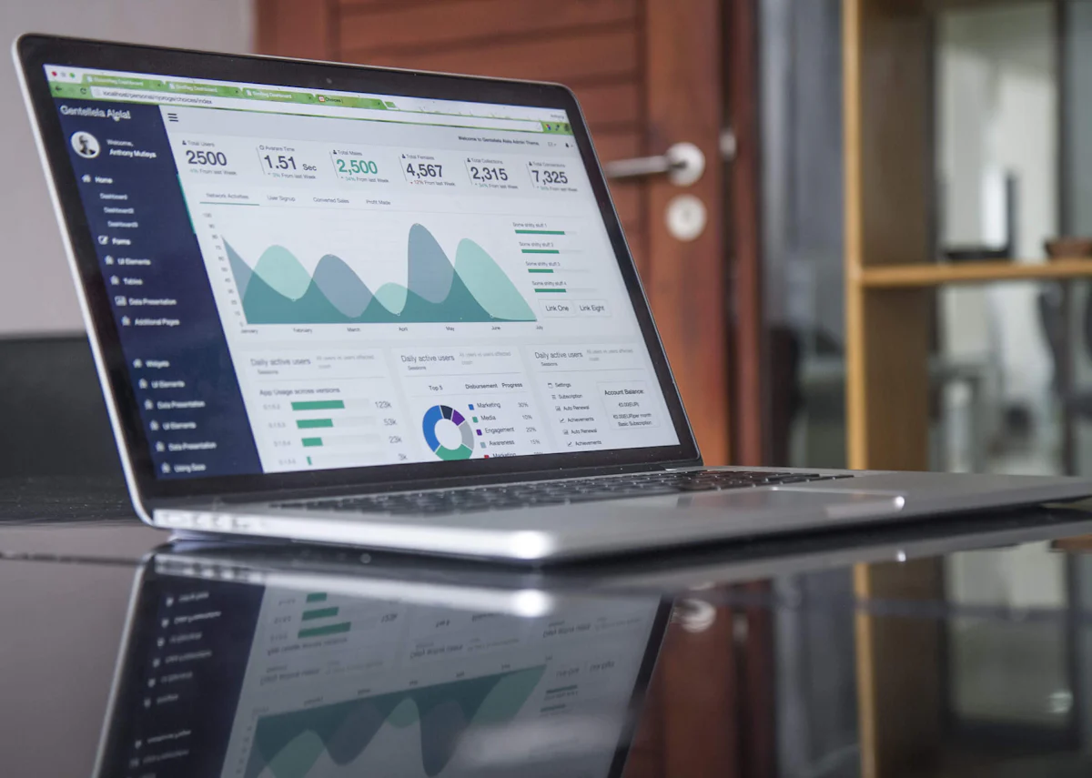 Laptop showing financial charts on a glass table